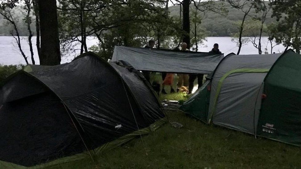 Campers next to tents next to lakes