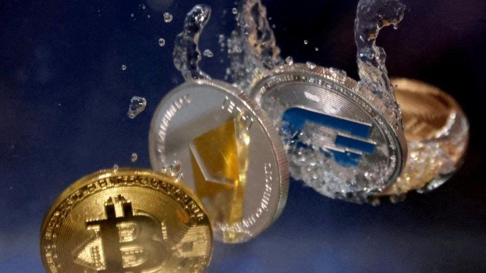 Representations of cryptocurrencies plunge into water in this illustration taken
