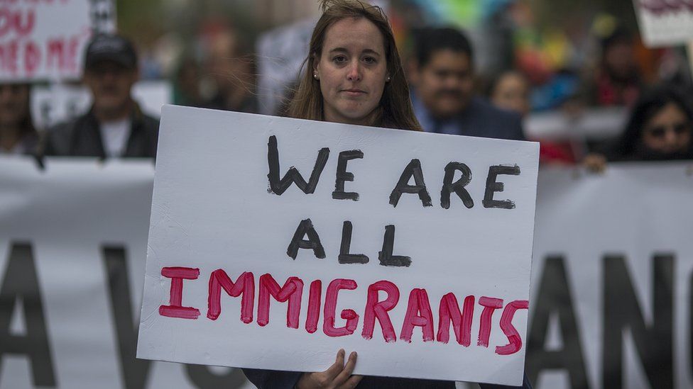 A girl holds a sign reading "We Are All Immigrants" on a May Day march on 1 May 2018 in Los Angeles, California.