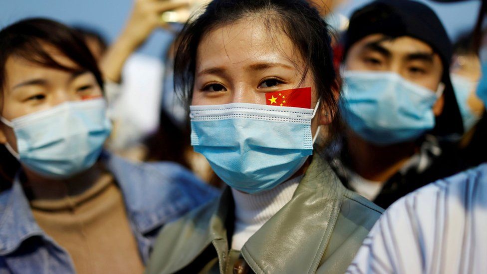 A person watches the flag raising ceremony in Beijing