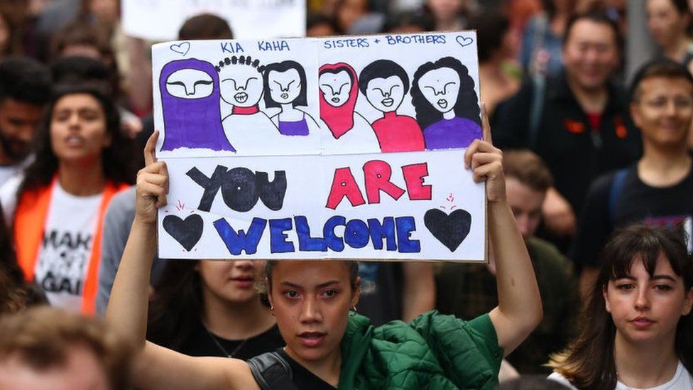 A protester at an anti-racism rally in Melbourne holds upa sign reading "You are welcome"
