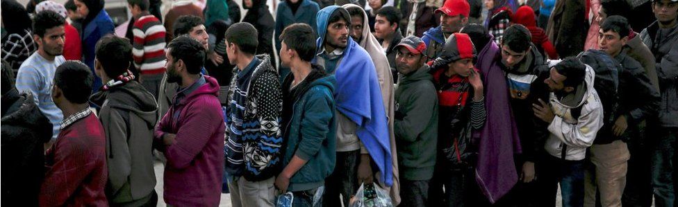 Refugees line up for a food distribution on Lesbos