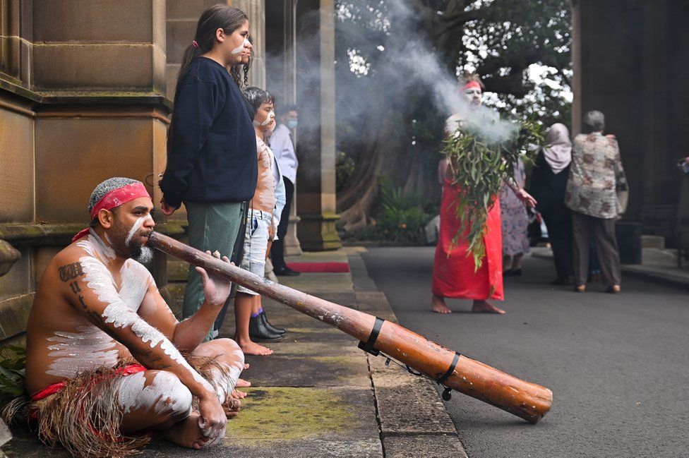 Празднование восшествия на престол в Сиднее, Австралия, включая церемонию курения аборигенов и мужчину, играющего на дигериду