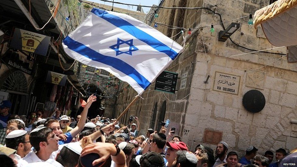 Young people wave an Israeli flag as they celebrate Jerusalem Day