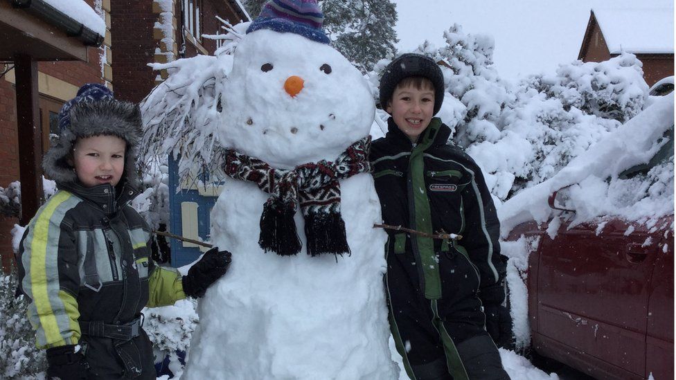 Two boys with a snowman