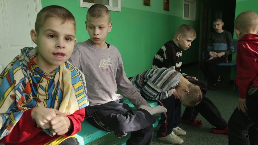 Young boys sit on a bench in their wing at the Vesnova Home for Invalid Children