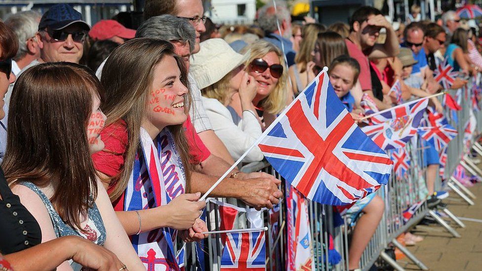 Members of the public cheer as Queen Elizabeth II meets locals during her Diamond Jubilee visit to the Isle of Wight on July 25, 2012 in Cowes, England.