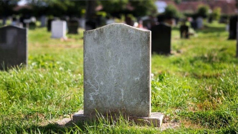 A headstone in a graveyard