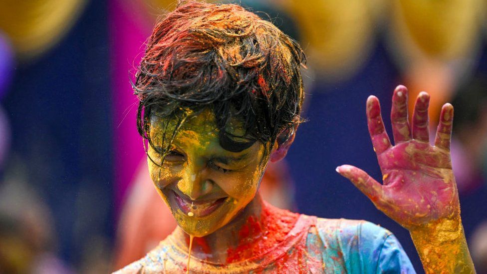 A boy dripping of colours in southern India's Chennai city