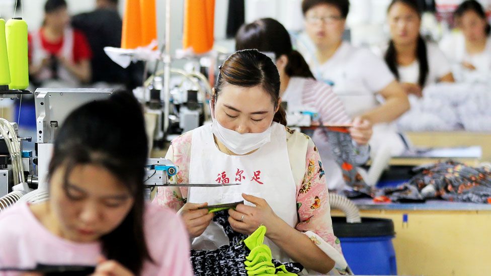 Chinese employees work on socks that will be exported at a factory in Huaibei in China's eastern Anhui province