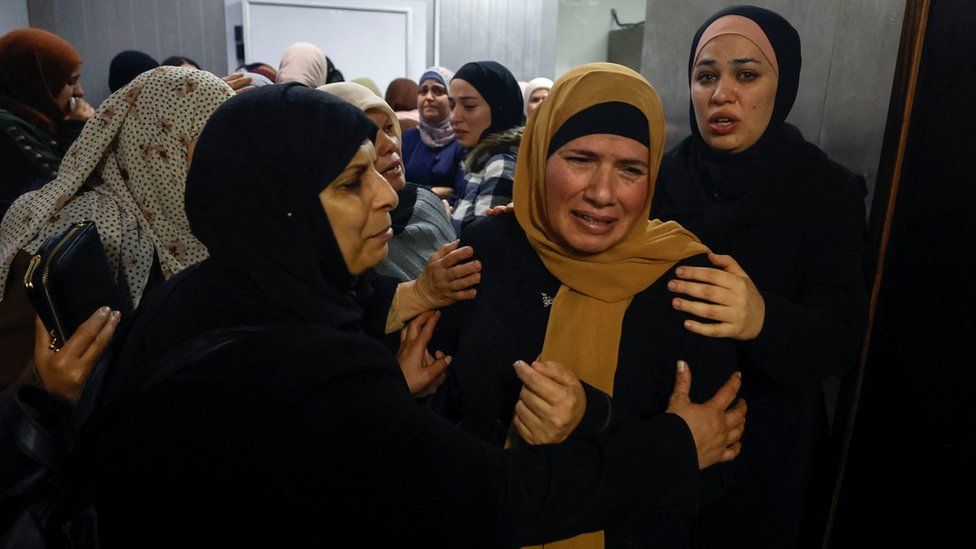 The mother of Palestinian brothers Jawad Rimawi, 22, and Thafer Rimawi, 21, mourns at a hospital in Ramallah before their funerals (29 November 2022)