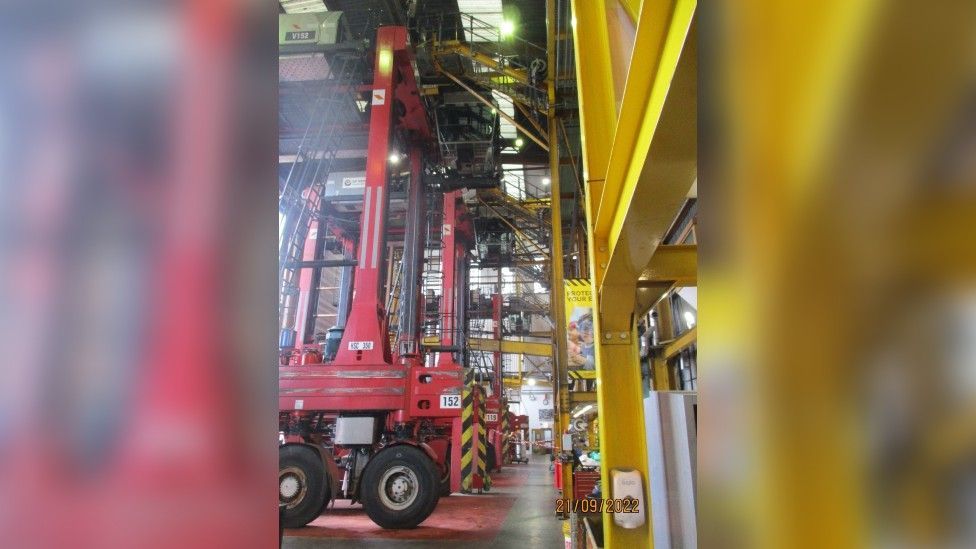 A straddle carrier parked inside a warehouse, showing the distance Mr Hooper fell