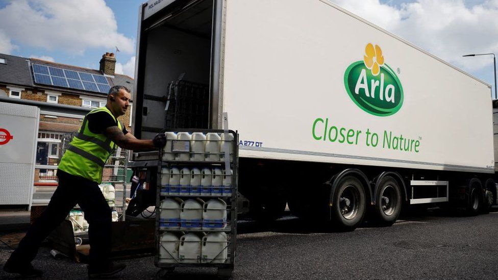 A lorry driver for Arla Foods makes a milk delivery