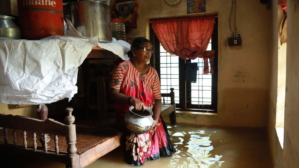 Una mujer sentada en su casa inmersa en agua Kochi
