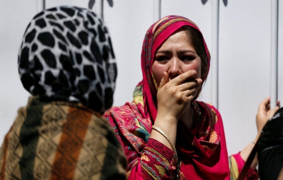 Bereaved women cover their faces in shock outside a hospital after a truck-bomb attack in Kabul on 31 May 2017