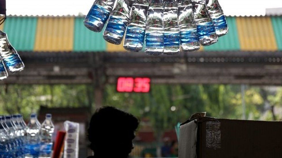 An Indian vendor sells drinking water at a railway platform