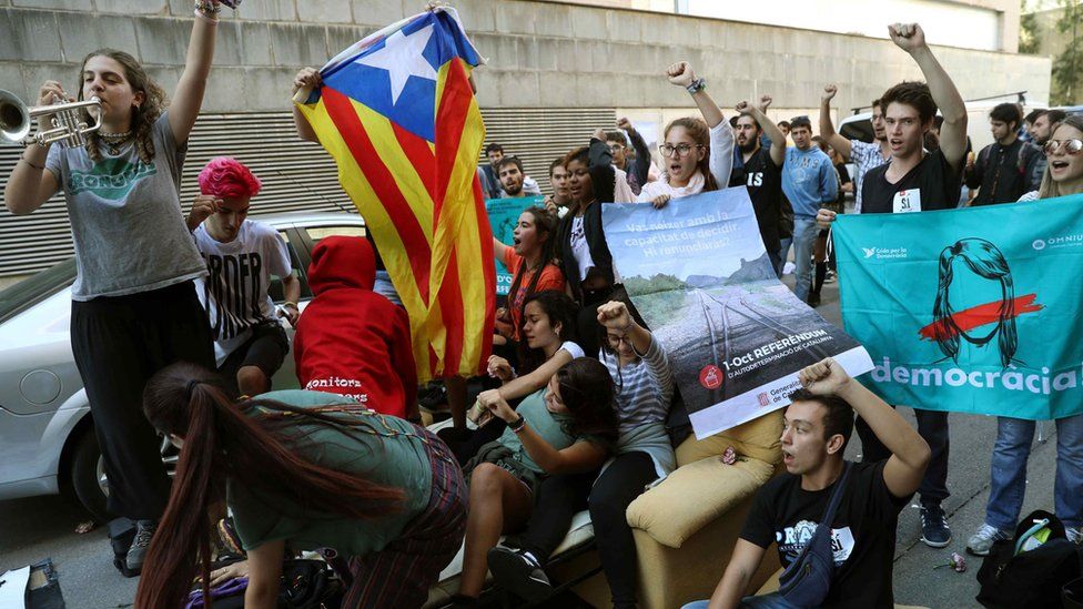 People stage a sit-down protest in front of the Unipost delivery company"s offices in Terrassa