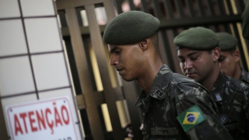 Soldiers visit people's homes during an operation to kill the Aedes aegypti mosquito that spreads the Zika virus in the Tijuca neighborhood of Rio de Janeiro (15 February 2016)