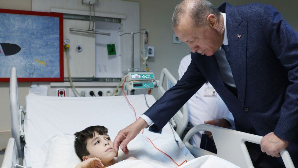 Президент Турции Реджеп Тайип Эрдоган (справа) посещает пережившую землетрясение Алейну Олмез и других пациентов, находящихся на лечении в Детской больнице медицинского факультета Университета Анкары после того, как их перевезли из пострадавших от землетрясения регионов Турции 22 февраля 2023 г.