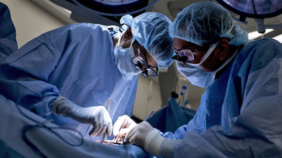 Surgeons at work on a patient in an operating theatre