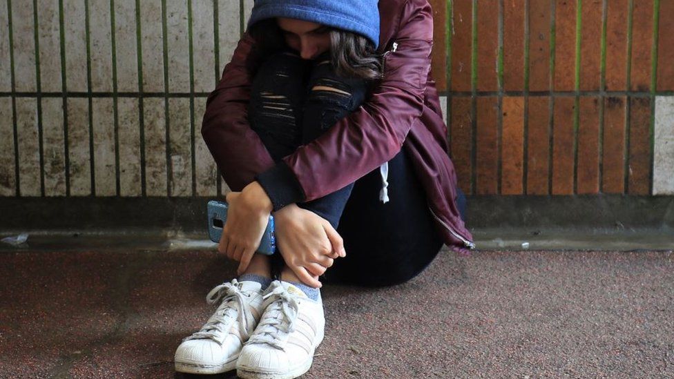 Woman sitting on the floor holding her phone