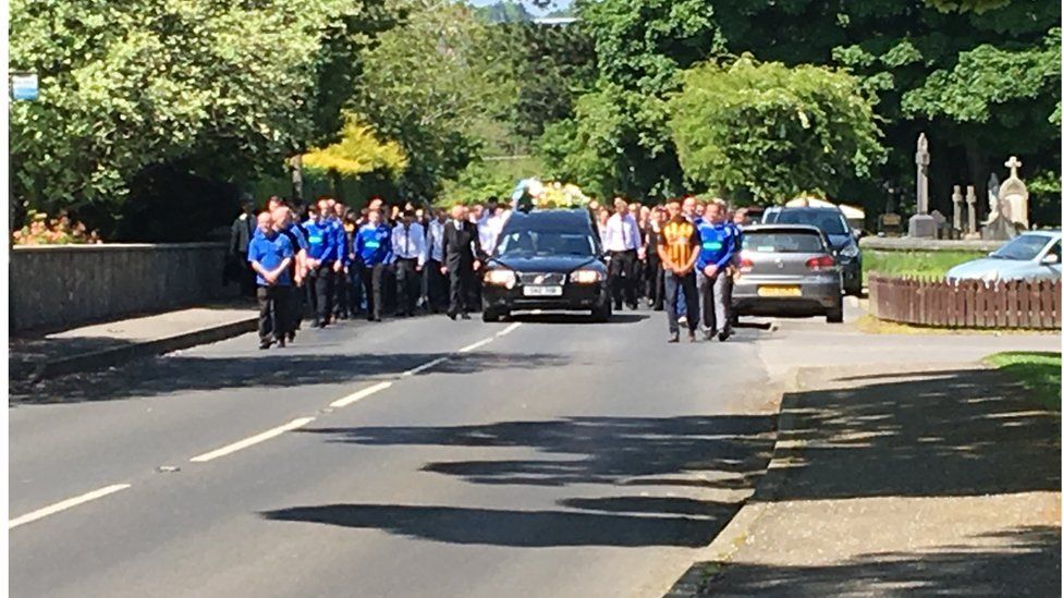 The funeral cortege makes its way to the church