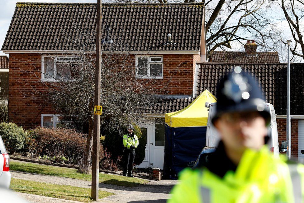 Police officers stand guard outside the home of Sergei Skripal