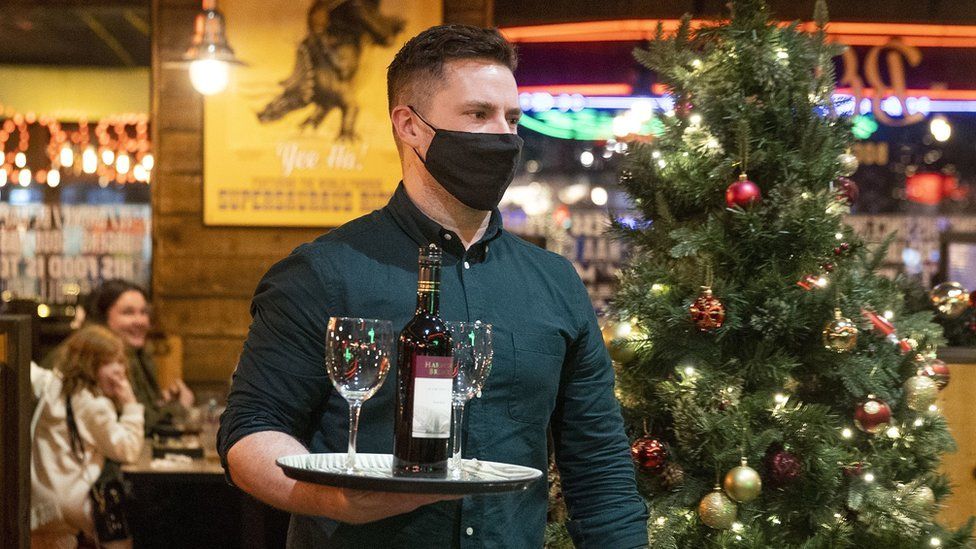 A waiter holding a tray of wine and wine glasses