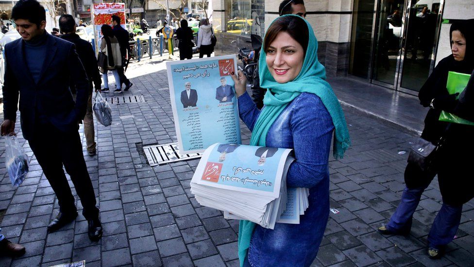 An Iranian woman hands out fliers for reformist candidates in Tehran (26 February 2016)