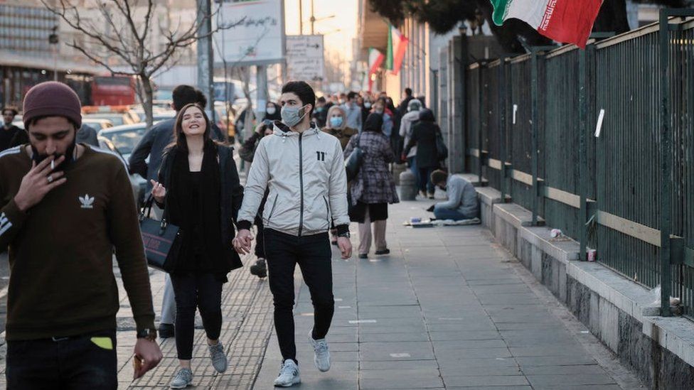 People walk down a street in Tehran, Iran (February 1, 2021)