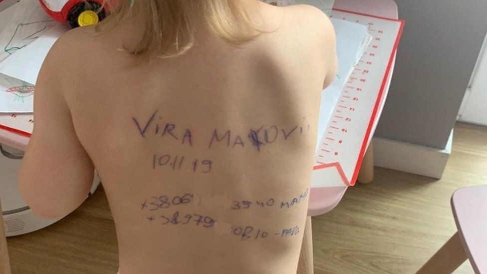 Image shows writing on toddler's back