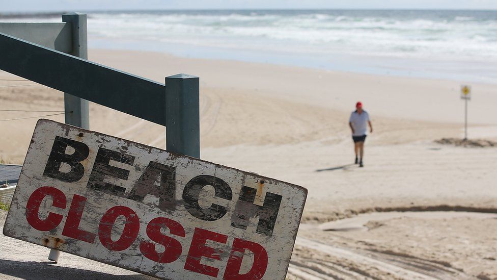 Sign reads "beach closed after fatal shark attack"