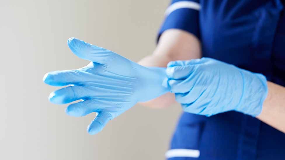 nurse putting on gloves