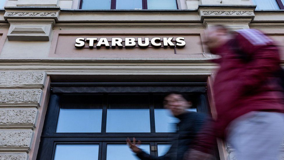 people walk past Starbucks in Moscow