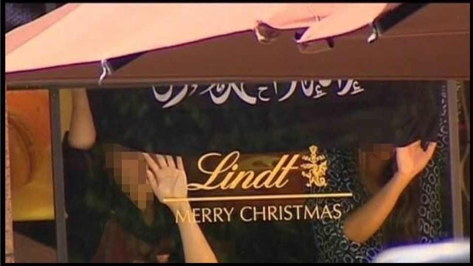 A screen grab from Channel 7 News, Sydney, via Australian Associated Press shows two women hostages inside the Lindt Cafe in Sydney on 15 December 2014