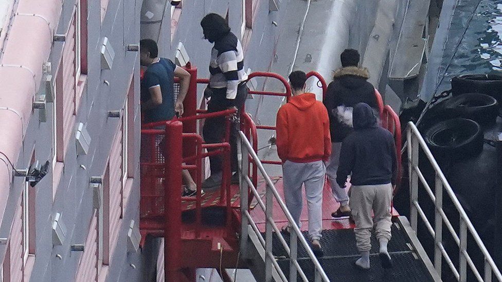 Migrants boarding the barge