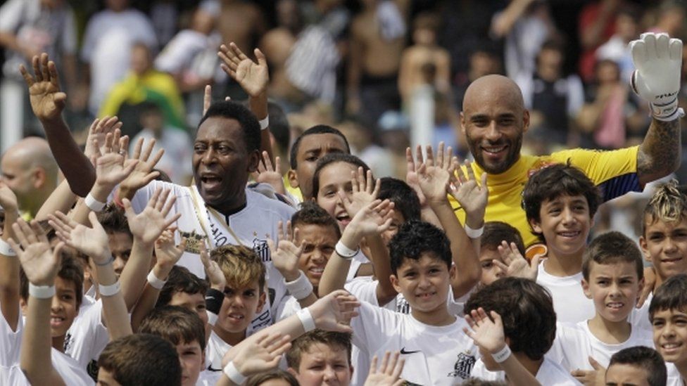 Pele (left) and Edinho (in yellow, right) during an event at Santos Football Club in April 2012