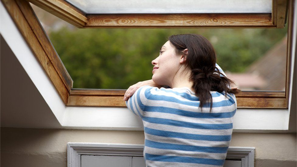 Stock shot of woman looking out of window