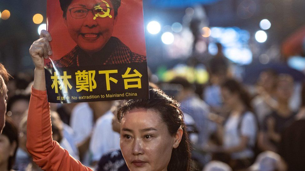 A woman holds a poster of Hong Kong Chief Executive Carrie Lam, against a proposed extradition law