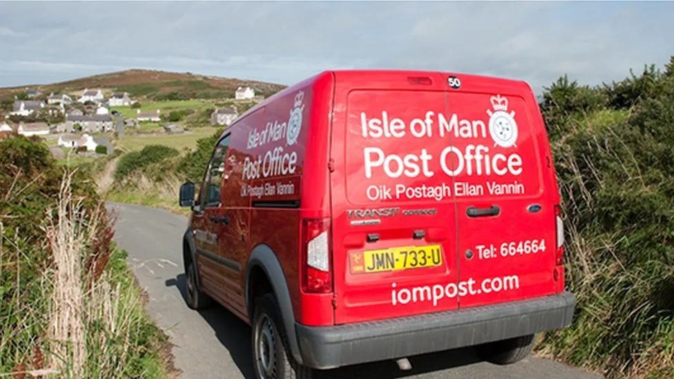 The back of an Isle of Man Post Office branded van in country roads