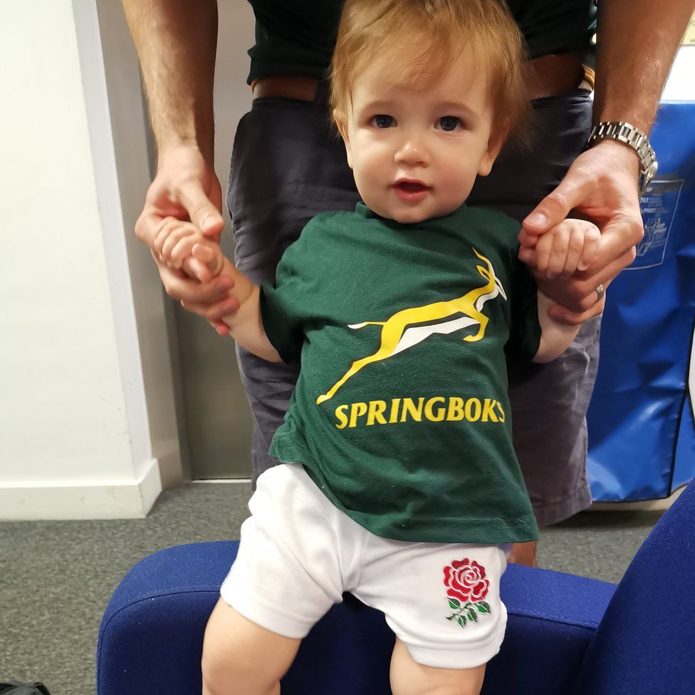 Finley held up by his dad in a South Africa top and England shorts