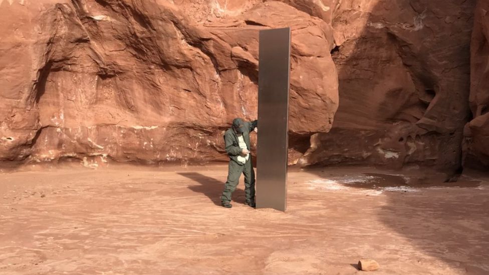 A wildlife official stands by the monolith