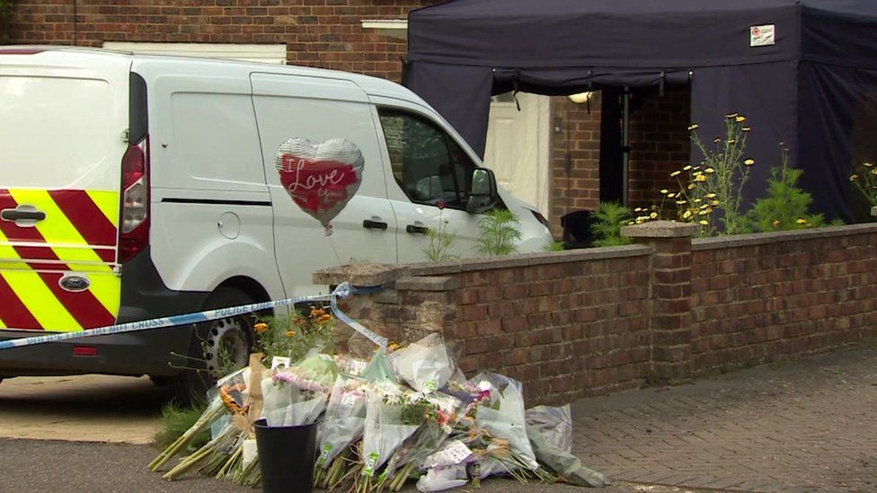 A van, balloon and flowers outside a house, which also has a gazebo set up outside
