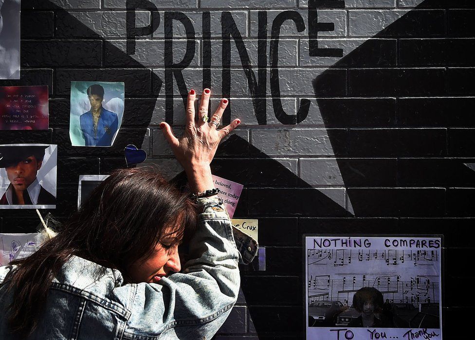 Prince fan touches the star of music legend Prince who died suddenly at the age of 57