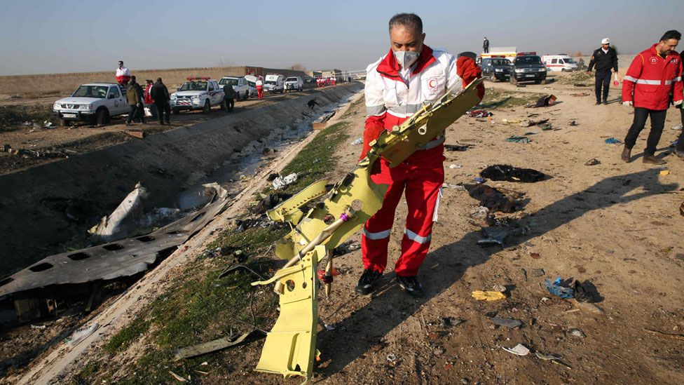 Red Crescent workers check the debris from the Ukraine International Airlines plane