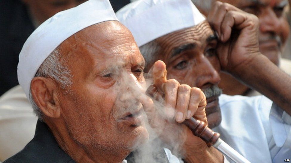 A member of the Indian 'Jat' community smokes a hukka pipe as activists take part in a protest in New Delhi on March 15, 2011.