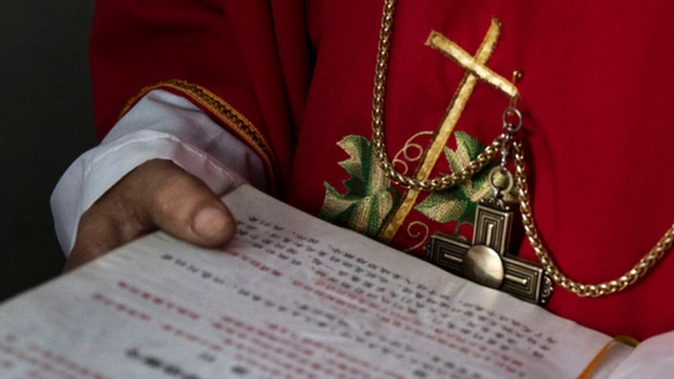 A Chinese Catholic deacon holds a bible at the Palm Sunday Mass during the Easter Holy Week, 19 April 9 2017