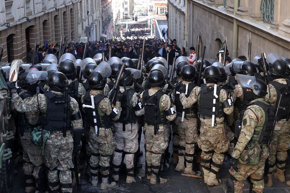 Military police line up in front of a crowd of densely packed supporters of Bolivian President Luis Arce during a protest against military personnel trying to enter the government headquarters in La Paz, Bolivia, 26 June 2024