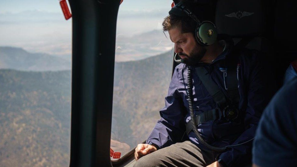 A handout photo made available by the Chilean presidency shows President Gabriel Boric in a helicopter overflying in the region of Valparaiso, affected by several forest fires, in Valparaiso, Chile, 03 February 2024.