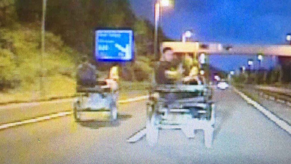 Two men racing their horse and traps on the M4
